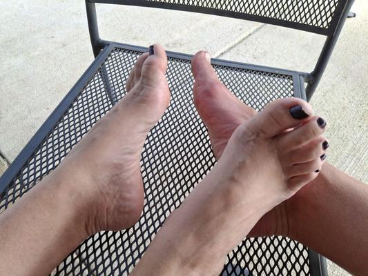 Jugando a pie al sol con nuestros pies y dedos de los pies de pedicura